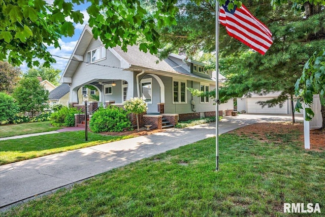213 S Hanover St, Metamora, IL 61548 - view of front facade with a porch, driveway, a front lawn, an outdoor structure, and a shingled roof