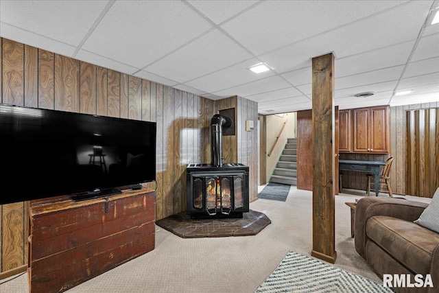 213 S Hanover St, Metamora, IL 61548 - carpeted living area with wooden walls, a drop ceiling, stairs, and a wood stove