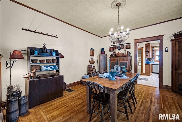 213 S Hanover St, Metamora, IL 61548 - dining area with a chandelier, ornamental molding, and hardwood / wood-style flooring