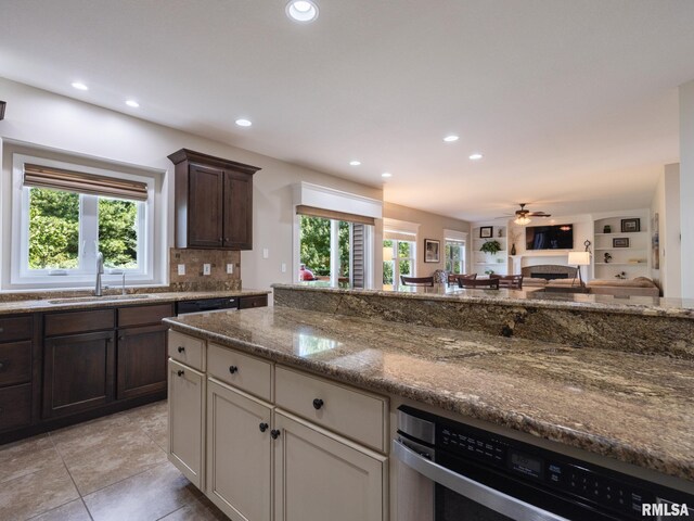 11014 N Saddlehorn Way, Dunlap, IL 61525 - kitchen with recessed lighting, dark stone countertops, backsplash, dark brown cabinetry, and light tile patterned floors