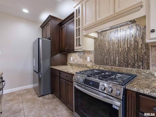 11014 N Saddlehorn Way, Dunlap, IL 61525 - kitchen featuring appliances with stainless steel finishes, dark brown cabinets, tasteful backsplash, glass insert cabinets, and light stone countertops