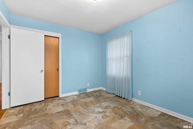 2400 W Callender Ave, West Peoria, IL 61610 - unfurnished bedroom featuring stone finish flooring and a closet