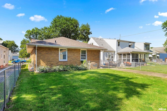 2400 W Callender Ave, West Peoria, IL 61610 - rear view of house with a sunroom, brick siding, and a fenced backyard