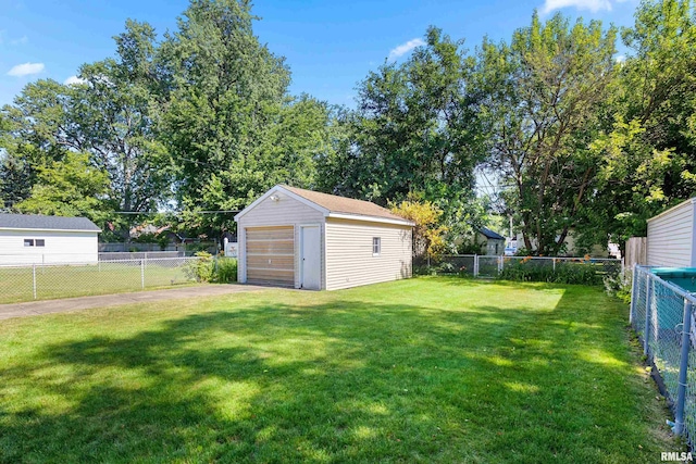 2400 W Callender Ave, West Peoria, IL 61610 - fenced yard featuring driveway, a detached garage, and an outdoor structure