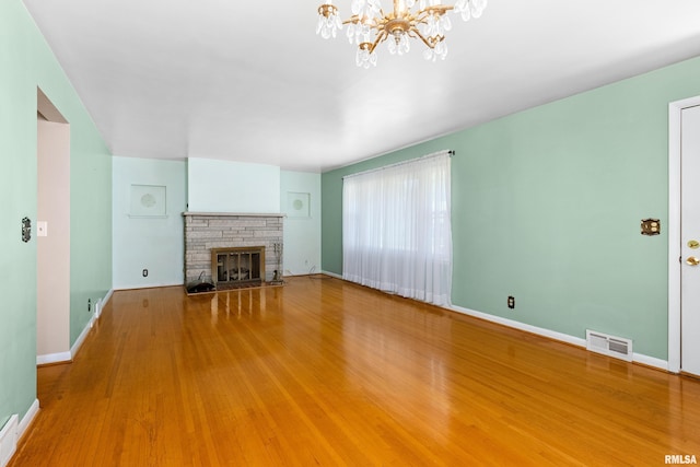 2400 W Callender Ave, West Peoria, IL 61610 - unfurnished living room featuring a chandelier, wood finished floors, and a brick fireplace