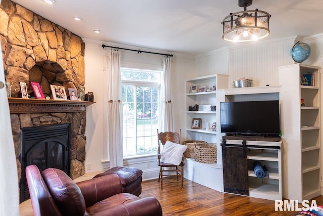 306 W Fremont St, Elmwood, IL 61529 - living area with crown molding, wood finished floors, and a stone fireplace