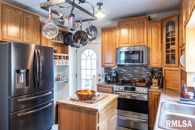306 W Fremont St, Elmwood, IL 61529 - kitchen featuring appliances with stainless steel finishes, butcher block countertops, backsplash, glass insert cabinets, and a center island