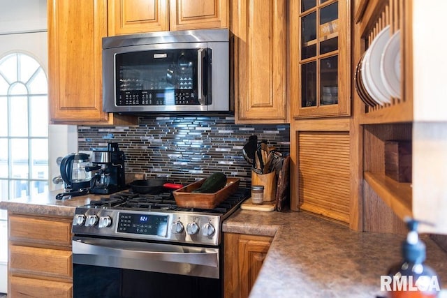 306 W Fremont St, Elmwood, IL 61529 - kitchen with stainless steel appliances, backsplash, brown cabinets, and glass insert cabinets