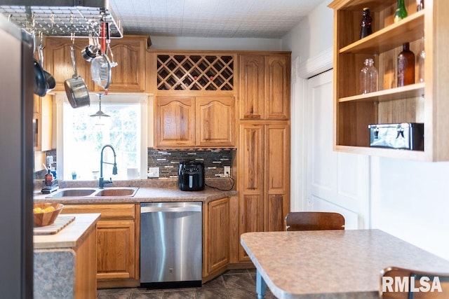 306 W Fremont St, Elmwood, IL 61529 - kitchen with stainless steel dishwasher, decorative backsplash, dark marble finish floors, light countertops, and brown cabinets
