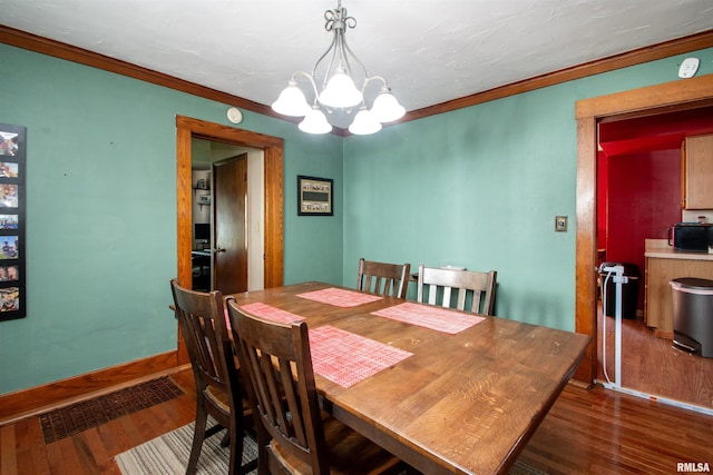 1926 W Callender Ave, West Peoria, IL 61604 - dining space with a chandelier, dark wood-style floors, and ornamental molding