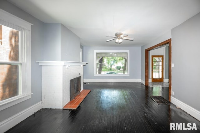 1121 N University St, Peoria, IL 61606 - unfurnished living room with wood finished floors, plenty of natural light, and a brick fireplace