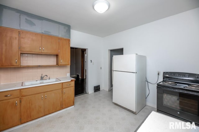 1121 N University St, Peoria, IL 61606 - kitchen with freestanding refrigerator, black / electric stove, light countertops, backsplash, and brown cabinets