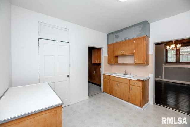 1121 N University St, Peoria, IL 61606 - kitchen with light countertops, tasteful backsplash, a chandelier, brown cabinetry, and open shelves