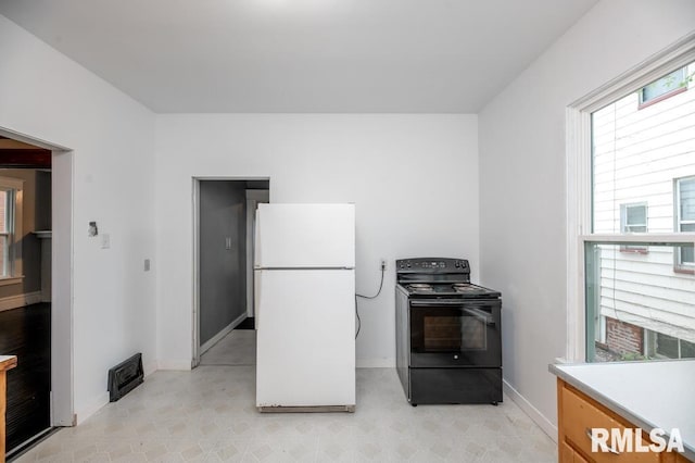 1121 N University St, Peoria, IL 61606 - kitchen featuring freestanding refrigerator, black electric range, and light countertops