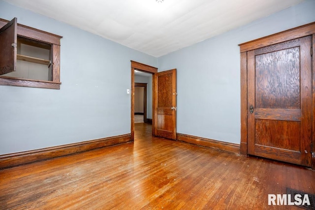1121 N University St, Peoria, IL 61606 - unfurnished bedroom featuring hardwood / wood-style flooring