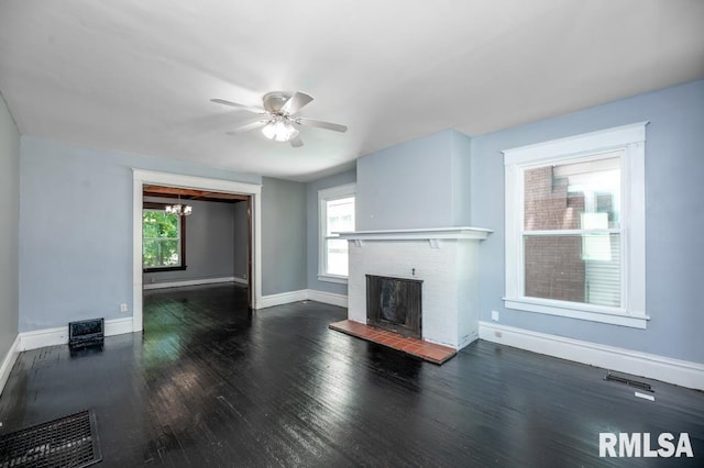1121 N University St, Peoria, IL 61606 - unfurnished living room with a brick fireplace, a ceiling fan, wood finished floors, and a chandelier