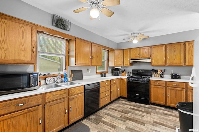 1029 N Santa Fe Ave, Chillicothe, IL 61523 - kitchen with black appliances, under cabinet range hood, ceiling fan, light countertops, and brown cabinets