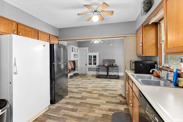 1029 N Santa Fe Ave, Chillicothe, IL 61523 - kitchen featuring black appliances, ceiling fan, light wood-type flooring, light countertops, and brown cabinetry