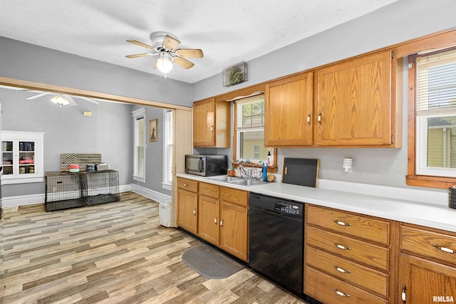 1029 N Santa Fe Ave, Chillicothe, IL 61523 - kitchen with black dishwasher, a ceiling fan, stainless steel microwave, light countertops, and light wood-style flooring