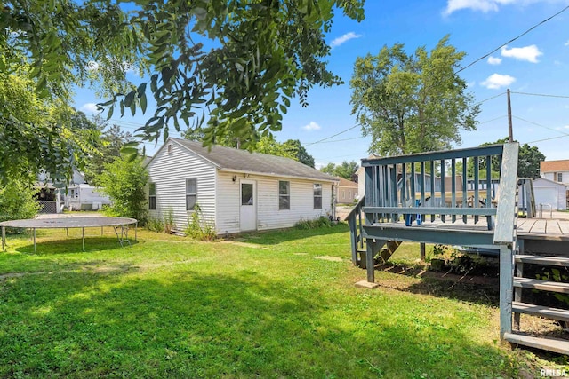 1029 N Santa Fe Ave, Chillicothe, IL 61523 - view of green lawn with a trampoline, a wooden deck, and an outdoor structure