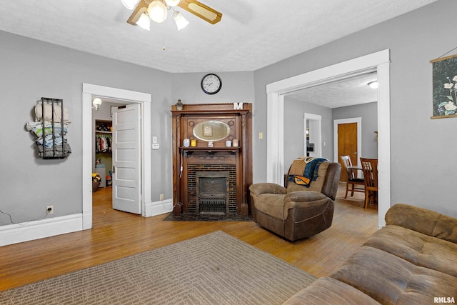 1029 N Santa Fe Ave, Chillicothe, IL 61523 - living room featuring a ceiling fan, wood finished floors, a textured ceiling, and a fireplace