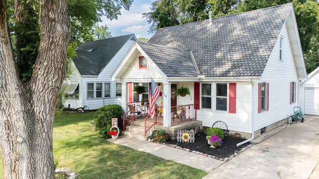 1108 Summer St, Pekin, IL 61554 - cape cod home featuring covered porch, a front lawn, and a garage