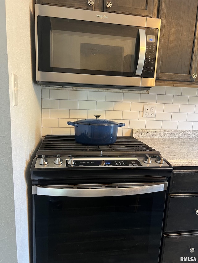 236 W Grant St, Macomb, IL 61455 - kitchen view of stainless steel appliances, decorative backsplash, light countertops, and a textured wall