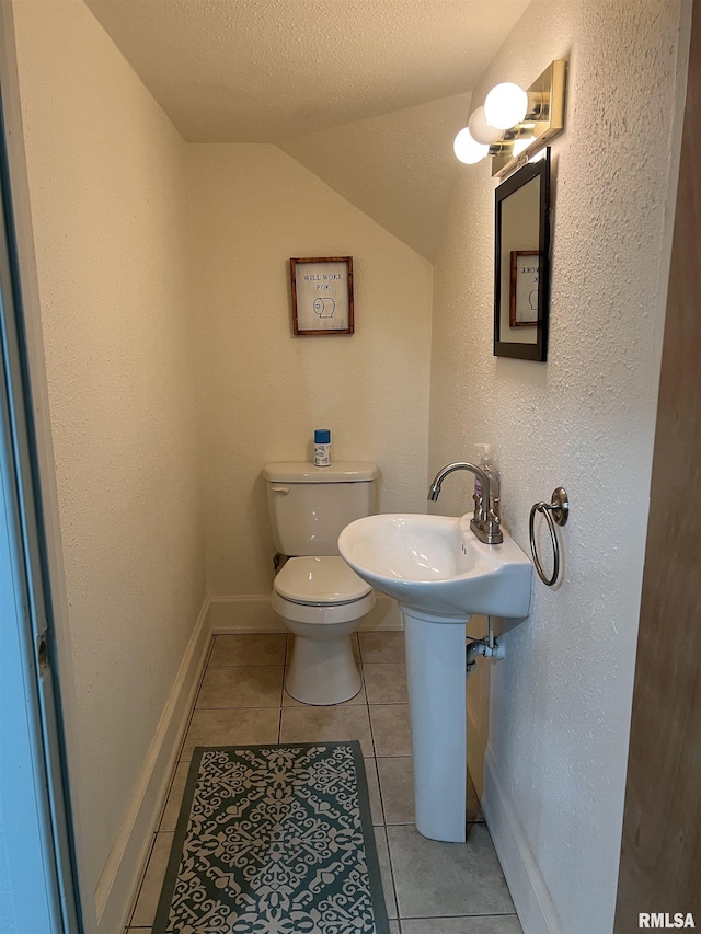 236 W Grant St, Macomb, IL 61455 - half bath featuring vaulted ceiling, tile patterned floors, a textured ceiling, and a textured wall