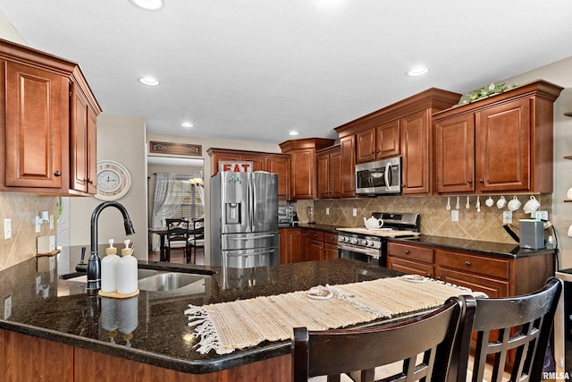 824 Debates St, Washington, IL 61571 - kitchen with appliances with stainless steel finishes, recessed lighting, a peninsula, tasteful backsplash, and dark stone countertops