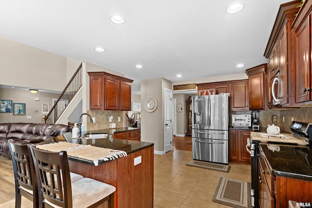 824 Debates St, Washington, IL 61571 - kitchen with stainless steel appliances, decorative backsplash, a peninsula, a breakfast bar, and light tile patterned floors
