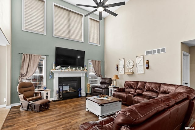 824 Debates St, Washington, IL 61571 - living room with a ceiling fan, a high ceiling, wood finished floors, plenty of natural light, and a glass covered fireplace