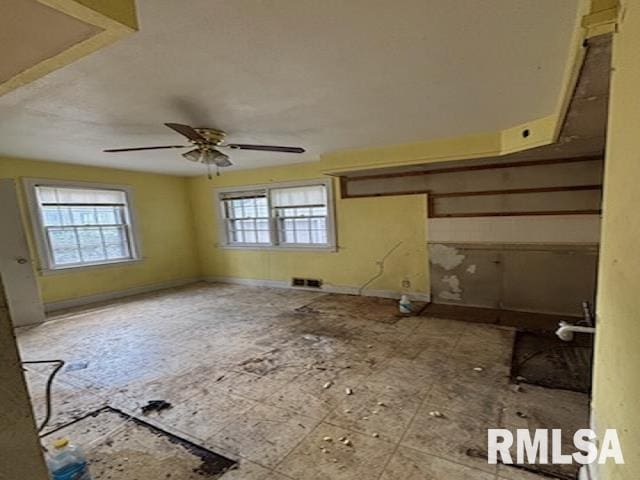 2714 W Laura Ave, West Peoria, IL 61604 - unfurnished living room featuring baseboards and ceiling fan