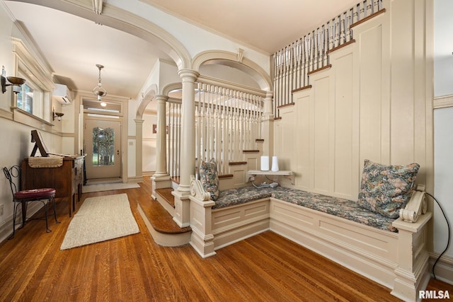 1227 W Barker Ave, Peoria, IL 61606 - foyer entrance featuring a wall mounted AC, a decorative wall, wood finished floors, arched walkways, and crown molding