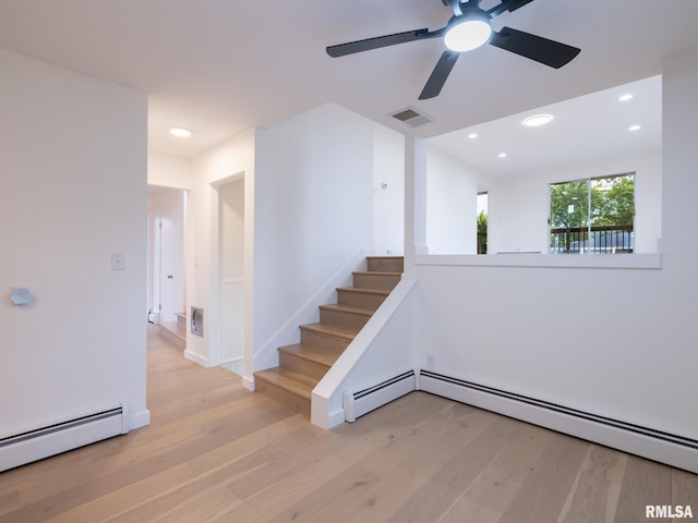 2810 Deveron Cir, Pekin, IL 61554 - spare room featuring a baseboard radiator, light wood-style floors, a ceiling fan, stairs, and recessed lighting