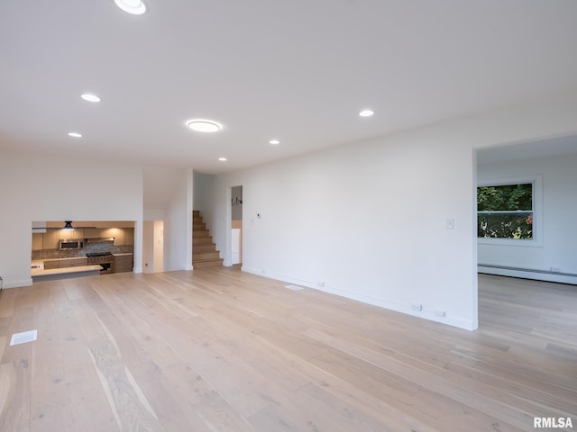 2810 Deveron Cir, Pekin, IL 61554 - unfurnished living room featuring a baseboard heating unit, light wood-style floors, stairway, and recessed lighting
