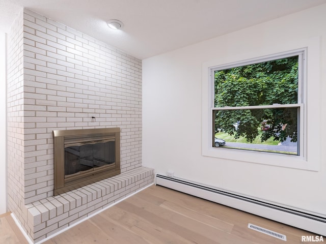 2810 Deveron Cir, Pekin, IL 61554 - unfurnished living room with a baseboard radiator, wood finished floors, and a fireplace