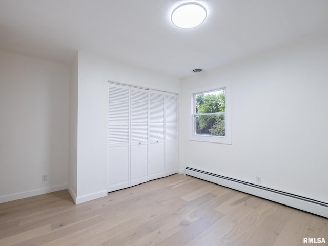 2810 Deveron Cir, Pekin, IL 61554 - unfurnished bedroom with a baseboard heating unit, light wood-style flooring, and a closet