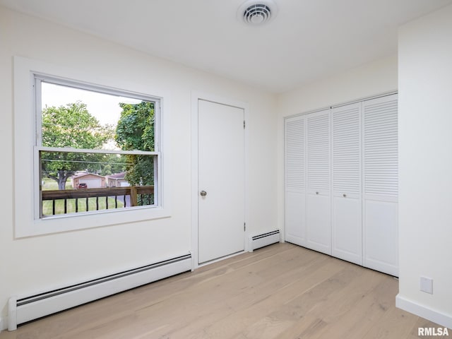 2810 Deveron Cir, Pekin, IL 61554 - unfurnished bedroom featuring a baseboard radiator and light wood finished floors