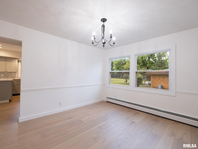2810 Deveron Cir, Pekin, IL 61554 - empty room featuring a baseboard heating unit, a chandelier, and light wood finished floors