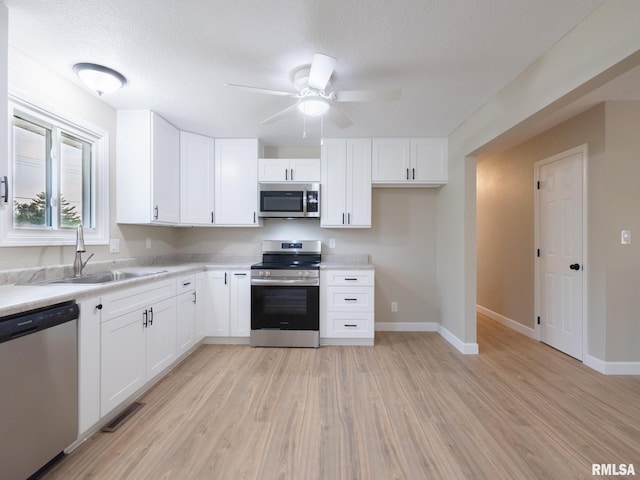 2922 W Larchmont Ln, Peoria, IL 61615 - kitchen featuring stainless steel appliances, light wood-type flooring, light countertops, and ceiling fan