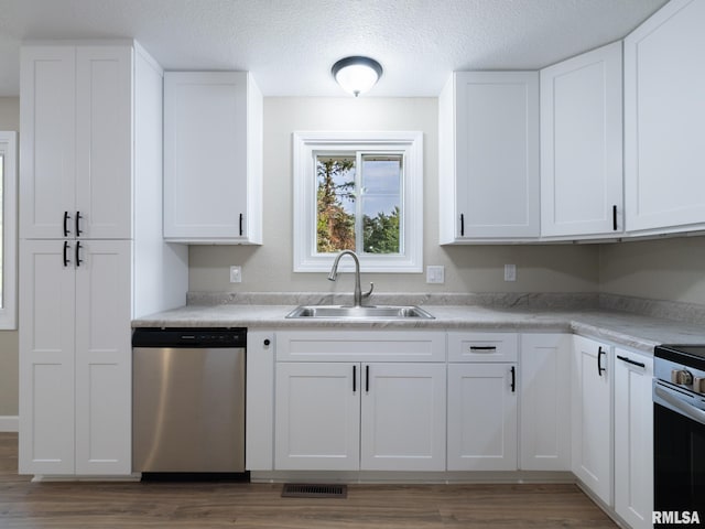 2922 W Larchmont Ln, Peoria, IL 61615 - kitchen featuring appliances with stainless steel finishes, wood finished floors, white cabinets, and a textured ceiling