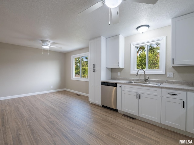 2922 W Larchmont Ln, Peoria, IL 61615 - kitchen featuring stainless steel dishwasher, a ceiling fan, light countertops, light wood finished floors, and a textured ceiling