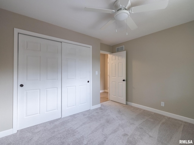 2922 W Larchmont Ln, Peoria, IL 61615 - unfurnished bedroom with light colored carpet, a closet, and a ceiling fan