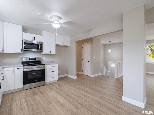 2922 W Larchmont Ln, Peoria, IL 61615 - kitchen featuring appliances with stainless steel finishes, light wood-style floors, light countertops, and a textured ceiling