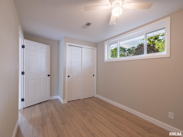 2922 W Larchmont Ln, Peoria, IL 61615 - unfurnished bedroom featuring light wood finished floors, a closet, and ceiling fan