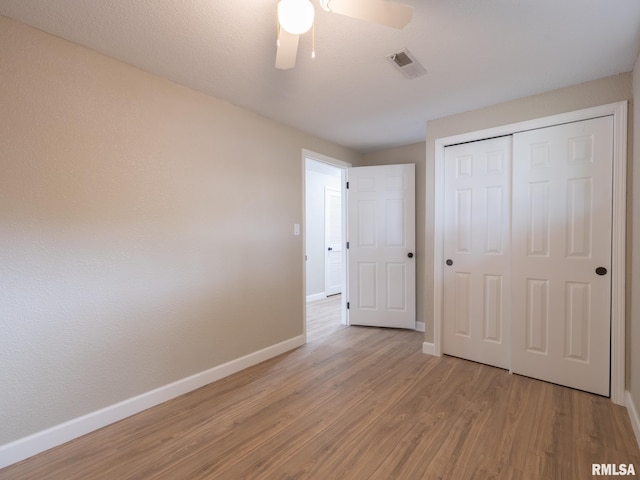 2922 W Larchmont Ln, Peoria, IL 61615 - unfurnished bedroom featuring light wood-style flooring, a closet, and a ceiling fan