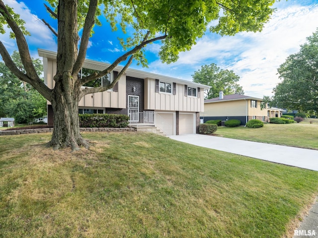 2922 W Larchmont Ln, Peoria, IL 61615 - split foyer home featuring a garage, board and batten siding, a front lawn, and concrete driveway