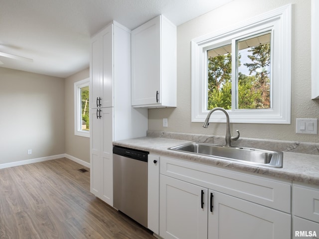 2922 W Larchmont Ln, Peoria, IL 61615 - kitchen with stainless steel dishwasher, wood finished floors, light countertops, white cabinets, and ceiling fan