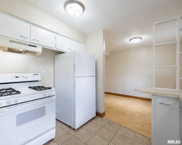 1505 N 9th St, Pekin, IL 61554 - kitchen featuring white appliances, under cabinet range hood, light tile patterned floors, white cabinets, and light countertops