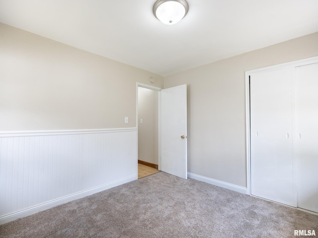 1505 N 9th St, Pekin, IL 61554 - unfurnished bedroom with a closet, light carpet, and a wainscoted wall